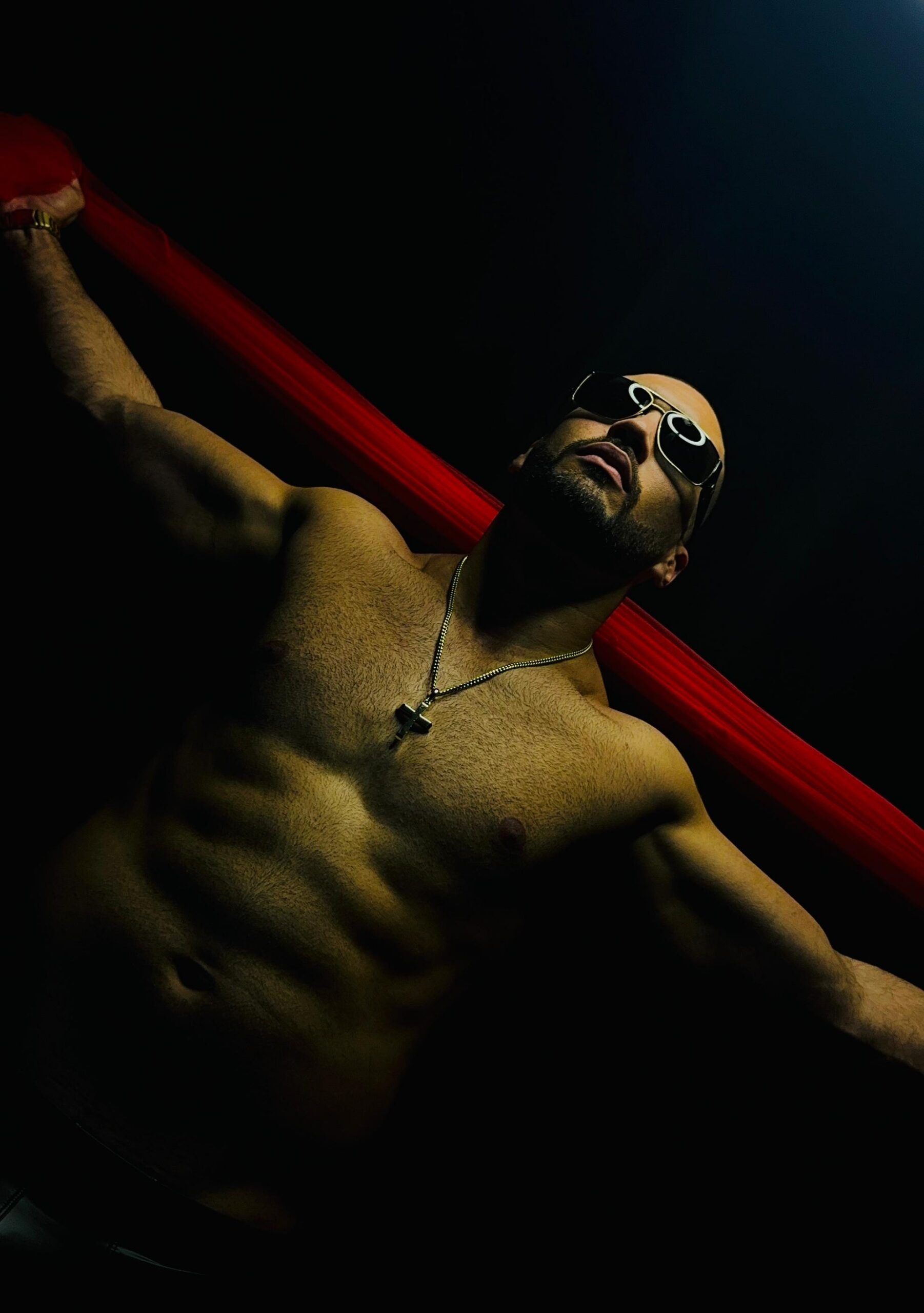 Dante reclining against a dramatic dark backdrop with a red fabric accent